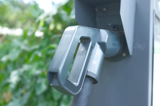 EV Car or Electric car at charging station with the power cable supply plugged .