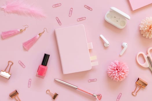 Hardcover notebook and Pink school accessories on pastel pink, top view, textbook mockup. Girly workplace with scissors, pencils, pen, paperclips, earrings and watch. Back to school concept