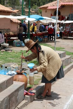 Woman is fetching a Drink in Raqui. Peru