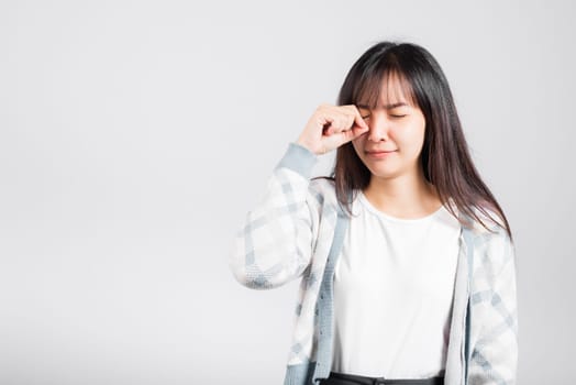 Unhappy woman bad mood her cry wipe tears with fingers, Asian beautiful young female stress feeling sad unhappy crying, studio shot isolated on white background with copy space