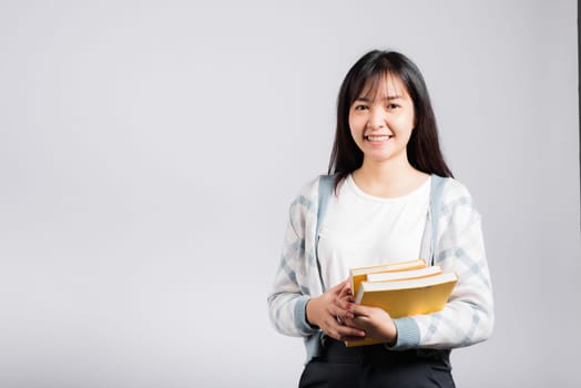 Woman teen smiling holding and hug embrace favorite book for lover, Portrait of beautiful Asian young female person teacher studio shot isolated on white background, education concept