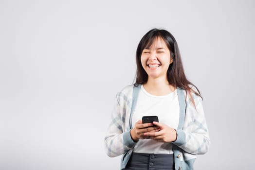 Woman excited read social network feedback on smartphone studio shot isolated white background, young female smiling typing sms message on mobile phone in social media