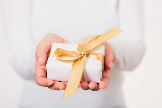 Valentine Day. Woman beauty hands holding small gift package box present wrapped paper with ribbon, Christmas, New year, Birthday holiday background concept