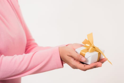 Valentine Day. Female beauty hands holding small gift package box present wrapped paper with ribbon isolated on white background, Christmas, New year, Birthday holiday background concept