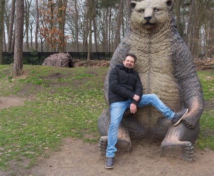 Man in the arms of a brown bear. The theme of friendship between humans and animals.
