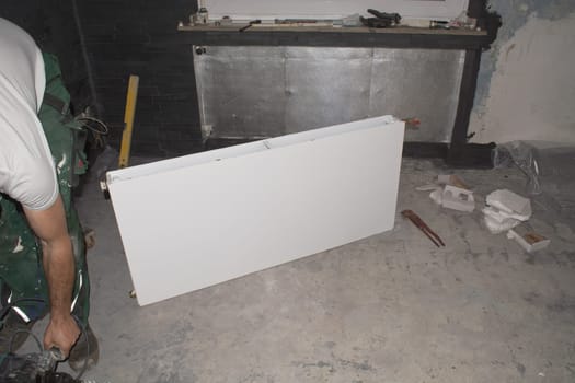 A heating installer installs a heater