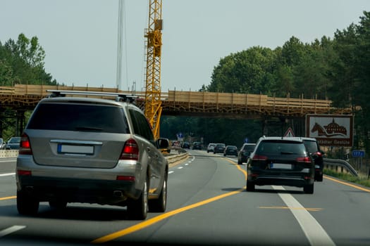 Various cars in a construction site area with construction crane on a german highway