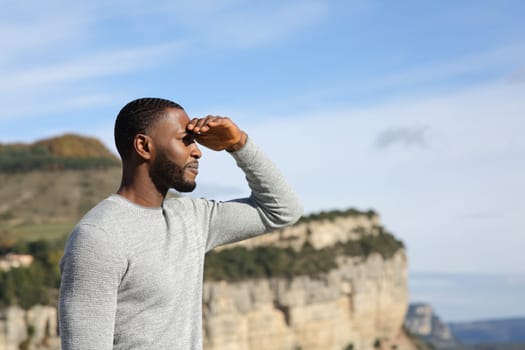 Man with black skin contemplating with hand on forehead