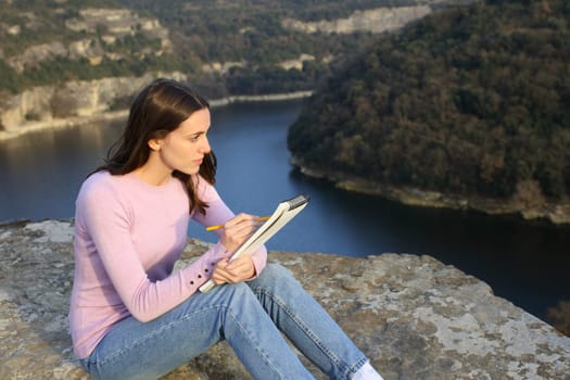 Woman drawing on notebook in nature