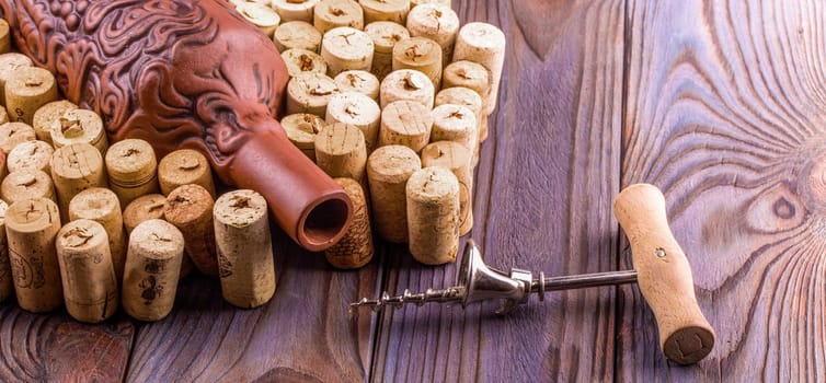 The Clay bottle, metal corkscrew and cork on a wooden table