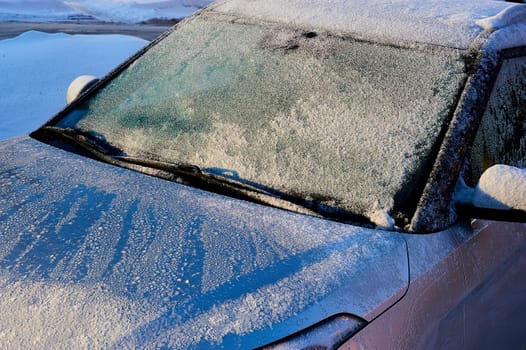 The windshield covered with frost at the car on a sun winter day. High quality photo