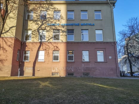Vilnius, Lithuania. - 28.02.2022: The wall of the facade of the Vilnius Humanitarian School with children's inscriptions in chalk in Lithuanian: Freedom to Ukraine . Sign in Lithuanian Vilnius Humanitarian School
