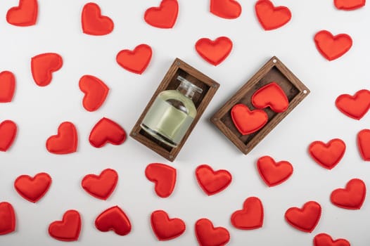 Valentine day white wood background with gift box with home aroma fragrance diffuser with red hearts. Valentines day gift or love concept