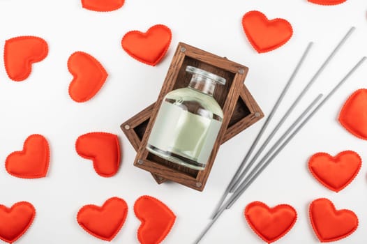 Valentine day white wood background with gift box with home aroma fragrance diffuser with red hearts. Valentines day gift or love concept