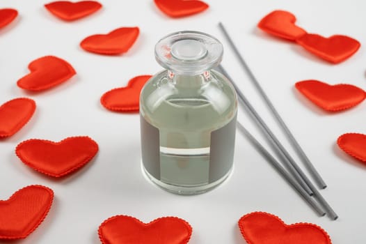 Valentine day white wood background with gift box with home aroma fragrance diffuser with red hearts. Valentines day gift or love concept