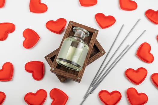 Valentine day white wood background with gift box with home aroma fragrance diffuser with red hearts. Valentines day gift or love concept