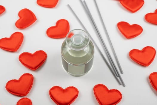 Valentine day white wood background with gift box with home aroma fragrance diffuser with red hearts. Valentines day gift or love concept
