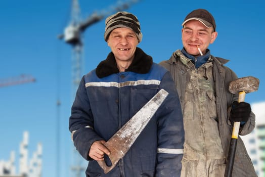 Two bad unskilled builder workers in bad dirty tattered uniform with bad tools. Concept of unskilled workers or crooks or poor quality workers