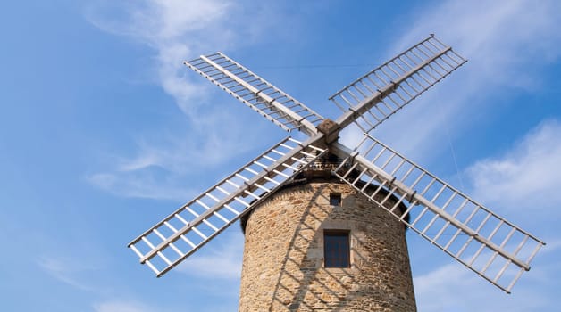 A low angle shot of a windmill under the cloudy sky