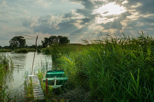 A boat in the reeds and the sun's rays, Stankow, Lubelskie, Poland