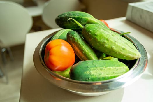 Fresh tomatoes and cucumbers in a bowl, summer day