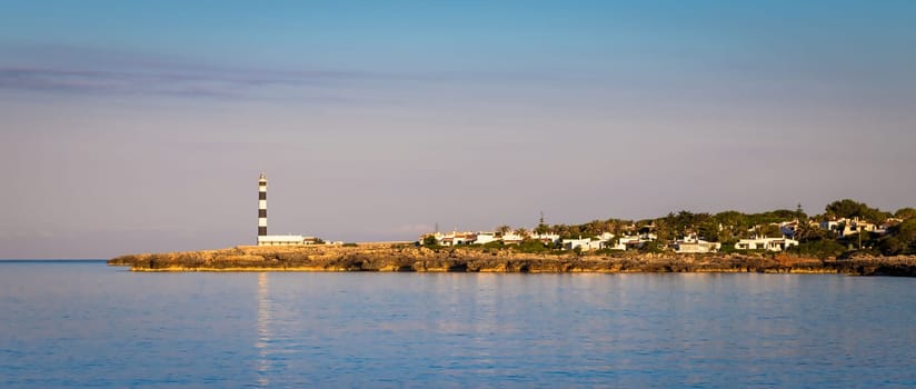 MINORCA ISLE - SPAIN - CIRCA AUGUST 2020: scenic Artrutx Lighthouse at sunset, famous landmark of the Isle