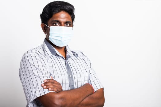 Closeup Asian handsome black man wearing surgical hygienic protective cloth face mask against coronavirus and stand crossed arm, studio shot isolated white background, COVID-19 medical concept