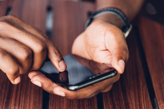 Happy Asian hand black man person holding a modern smart phone and touching a finger to blank screen device technology and connecting networking online at the coffee cafe shop