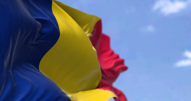 Detail of the national flag of Chad waving in the wind on a clear day. Chad is a landlocked country at the crossroads of North and Central Africa. Patriotism. Selective focus.