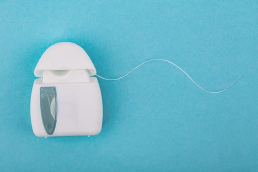 Concept dental Floss over light blue background