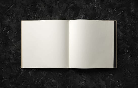 Blank brochure mock up on black stone background. Flat lay.