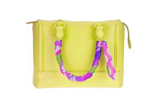 A fashionable female yellow luxury handbag decorated with colorful cloth and isolated on a white background. Fashionable womans accessories. Advertising.