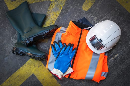 professional protective clothing for construction sites and building on a concrete background with traffic marks. Construction, industry and worker protection