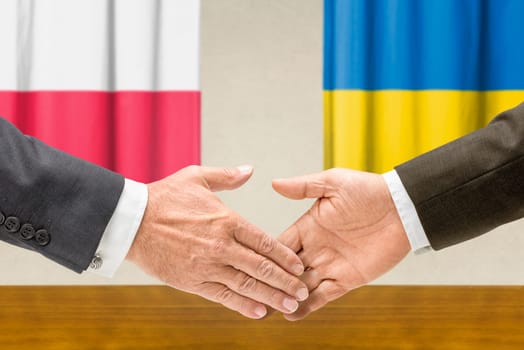 Representatives of Poland and Ukraine shake hands