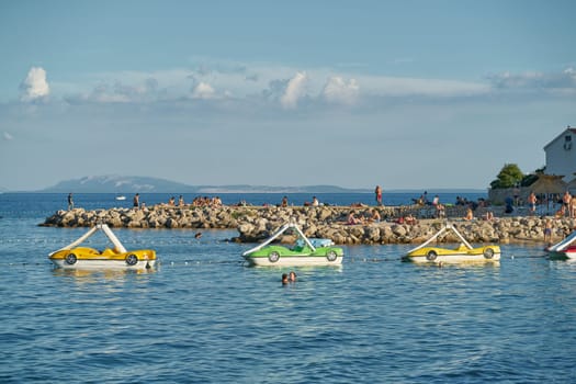 Bathing bay with pedal boats on the coast of the Adriatic Sea near the town of Krk in Croatia