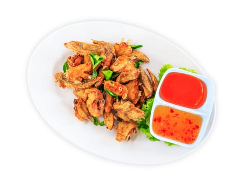 Fried chicken wings with sauce in white plate on white background