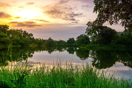 View of Colorful dramatic sky sunset or sunrise with clouds background on Water River in Forest, Sky with cloud in nature and travel concept.