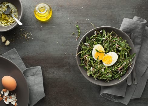 Fresh spring green dandelion salad with eggs on a plate