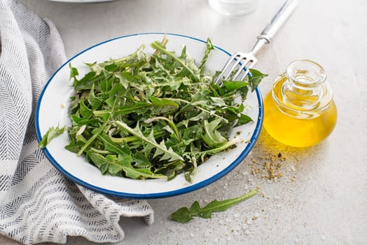 Fresh dandelion salad with dressing. Healthy spring food meal