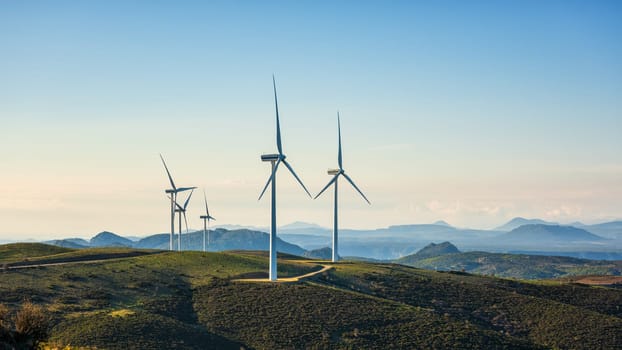 Wind turbines on a beautiful blue sky in a mountain wind farm in Sardinia. Renewable energy concept, green energy generation. Energy industry.