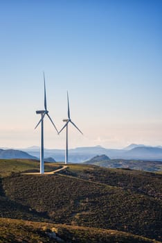 Wind turbines on a beautiful blue sky in a mountain wind farm in Sardinia. Renewable energy concept, green energy generation. Energy industry.
