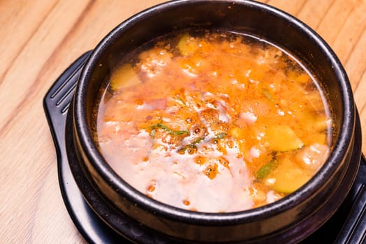 Kimchi soup in hot black iron pot, Korean traditional Kimchi Jjigae soup in bowl in the restaurant, Japanese hot pot food