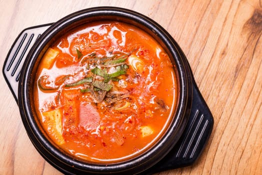 Kimchi soup in hot black iron pot, Korean traditional Kimchi Jjigae soup in bowl in the restaurant, Japanese hot pot food