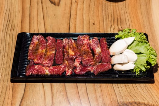 Premium frozen raw pork on plate, Korean traditional style fresh pork beef belly BBQ, Japanese meat hot pot or Shabu in the restaurant, barbecue food