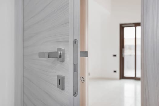 Closeup white open door, Real estate concept door handle.
