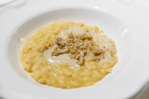Saffron risotto with nuts. Italian dish made from saffron, rice and vegetable bouillon and nuts. Close-up.
