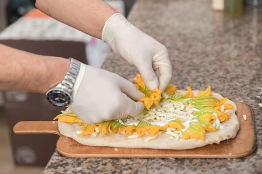 Pizza Art. The process of making pizza. Hands of chef with white gloves making pizza.