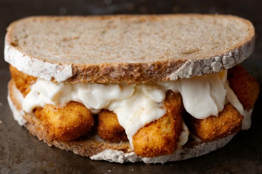 close up of rustic golden english fish fingers sandwich