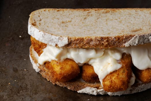 close up of rustic golden english fish fingers sandwich