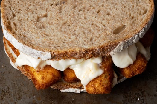 close up of rustic golden english fish fingers sandwich